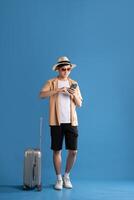 Portrait of Asian man posing on blue background, traveling in summer photo
