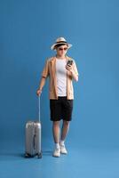 Portrait of Asian man posing on blue background, traveling in summer photo