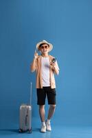 Portrait of Asian man posing on blue background, traveling in summer photo