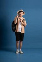 Portrait of Asian man posing on blue background, traveling in summer photo