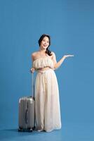 Portrait of asian girl posing on blue background, traveling in summer photo