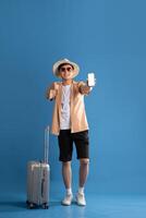 Portrait of Asian man posing on blue background, traveling in summer photo