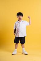 Portrait of adorable asian boy posing on yellow background photo