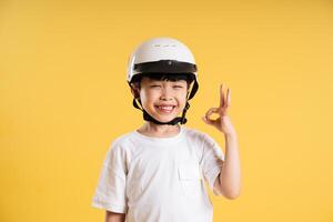 Portrait of adorable asian boy posing on yellow background photo
