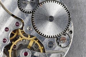 Clock mechanism close-up. Gears and cogs in clockwork watch mechanism photo