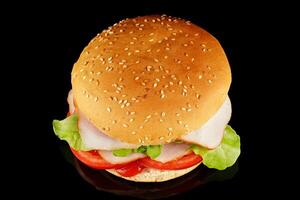 burger with lettuce, tomato, cheese and cutlet top view. burger isolated on black background photo