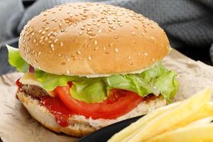 Tasty burger close-up. home made beef burger with tomato, cheese, beef and salad. photo