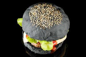 Black burger with lettuce, tomato, cheese and cutlet top view. photo