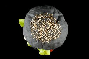 Black burger with lettuce, tomato, cheese and cutlet top view. photo