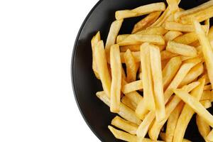 French fries in a black plate isolate. Appetizing fried potatoes. place for text cope space photo