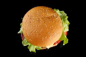 Burger appetizing top view on black. Meat hamburger flat lay photo