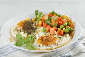 Fried eggs with vegetables. Traditional delicious breakfast and lunch. photo