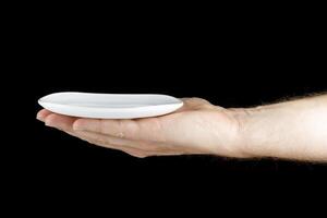 White saucer in hand of a Caucasian. photo