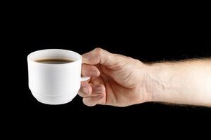 Hand holding white cup of coffee isolate photo