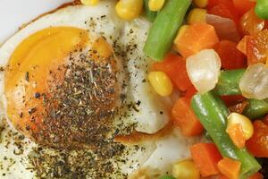 Fried eggs with vegetables. Traditional delicious breakfast and lunch. photo