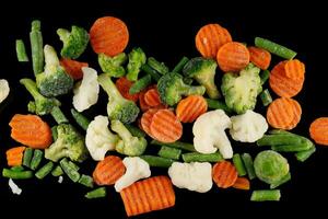 Frozen vegetables close-up on black. photo