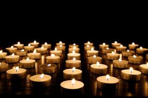 Many burning candles with shallow depth of field. Candles flicker in the dark photo