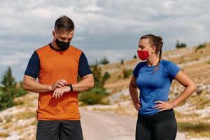 A couple dressed in sportswear runs along a scenic road during an early morning workout, enjoying the fresh air and maintaining a healthy lifestyle photo