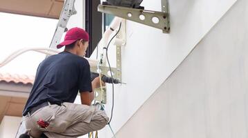Technician man install new air conditioning, Repairman service for repair and maintenance of air conditioners photo
