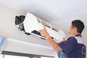 Technician man cleaned mold in the air conditioning system, Repairman washed dirty inside compartments air conditioner, Maintenance and service concepts photo