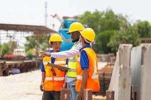 Construction workers at work, Foreman and worker team discussing on construction site with blurred concrete truck mixer in background photo