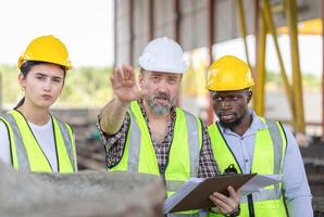 Engineer and foreman worker team checking project at precast concrete factory site, Engineer and builders in hardhats discussing on construction site photo
