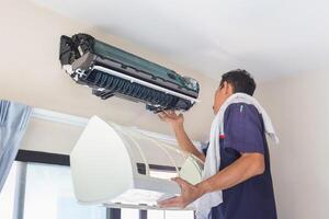 Technician man cleaned mold in the air conditioning system, Repairman washed dirty inside compartments air conditioner, Maintenance and service concepts photo