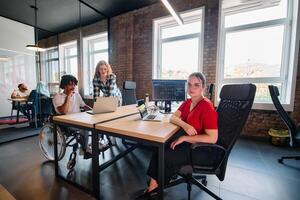 A diverse group of business professionals collaborates in a modern startup coworking center, utilizing a mix of paper-based and technological tools such as mobile phones and computers photo