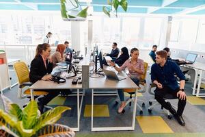 Collaborative process of multicultural skilled young business team during brainstorming meeting in office.Diverse group of young people dressed in formal wear cooperating on developing design project photo