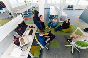 Top view photo of collaborative process of multicultural skilled young business team during brainstorming meeting in office.Diverse group of young people dressed in formal wear cooperating on