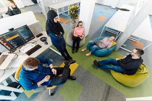 Top view photo of collaborative process of multicultural skilled young business team during brainstorming meeting in office.Diverse group of young people dressed in formal wear cooperating on