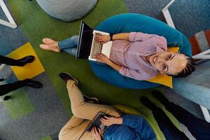 Top view photo of collaborative process of multicultural skilled young business team during brainstorming meeting in office.Diverse group of young people dressed in formal wear cooperating on