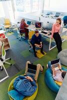 In a modern startup office, a diverse group of young and capable businesspeople engage in lively discussions about various projects, showcasing teamwork, innovation, and entrepreneurial spirit photo