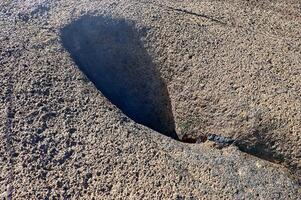 A geyser emerging from the surf in a rock on the beach in Tenerife. photo