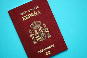 Red Spanish passport of European Union on blue background close up photo