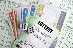 Green lottery tickets and iranian money bills on blank with numbers for playing lottery photo