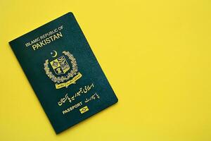 Green Islamic Republic of Pakistan passport on yellow background close up photo