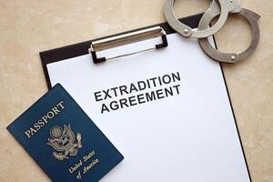 Passport of United States and Extradition Agreement with handcuffs on table photo