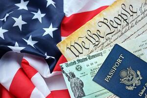 Preamble to the Constitution of the United States, US Passport and refund check on American Flag photo