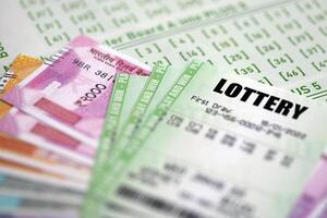 Green lottery tickets and indian rupees money bills on blank with numbers for playing lottery photo