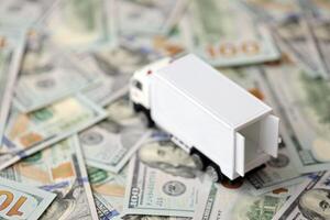 Delivery truck on hundred dollar bills banknotes. Background of moving or trucking concept photo