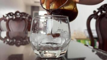 Pouring thick coffee into ice Pouring Cold Brewed Coffee over Ice. Making ice latte. Cold brew with ice and milk. video