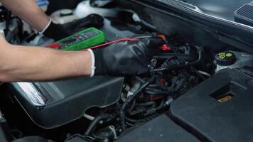 Technician uses multimeter voltmeter to check voltage level in car battery, close up. Service and Maintenance car battery video