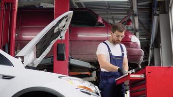 Technician uses multimeter voltmeter to check voltage level in car battery. Service and Maintenance car battery video