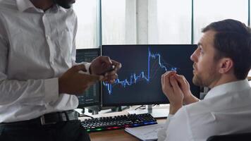 Diverse managers traders analysts discussing financial growth market at desk with pc graphs on screen video