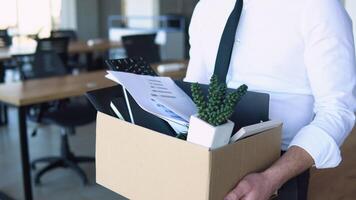 Sad dismissed worker are taking his office supplies with him from office video