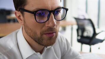 criptografia comerciante vestindo Óculos trabalhando olhando às computador tela refletindo dentro óculos analisando conectados negociação estoque troca mercado financeiro dados gráficos. fechar acima olho dentro óculos reflexão video