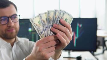 A man in business clothes with dollars. Cash in hands. Profits, savings. Stack of dollars. Man counting money. Dollars in man's hands. Success, motivation, financial flows, wealth. Stack of dollars video