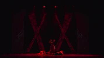 Silhouette of a person on stage with dramatic red lighting and a dark, moody atmosphere. video