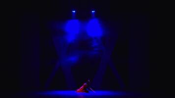 Silhouette of a person on stage with dramatic blue stage lighting, creating a mysterious atmosphere. video